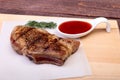 Grilled pork chop with Cranberry sauce on plate on wooden board Royalty Free Stock Photo