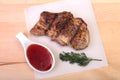 Grilled pork chop with Cranberry sauce on plate on wooden board Royalty Free Stock Photo