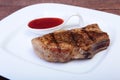 Grilled pork chop with Cranberry sauce on plate on wooden board Royalty Free Stock Photo