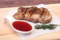 Grilled pork chop with Cranberry sauce on plate on wooden board Royalty Free Stock Photo