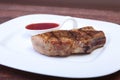 Grilled pork chop with Cranberry sauce on plate on wooden board Royalty Free Stock Photo