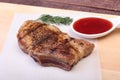 Grilled pork chop with Cranberry sauce on plate on wooden board Royalty Free Stock Photo