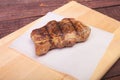 Grilled pork chop on plate on wooden board Royalty Free Stock Photo