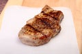 Grilled pork chop on plate on wooden board Royalty Free Stock Photo