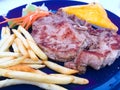 Grilled Pork chop Steak with gravy sauce, there are French fries and Salad with cream sauce on side dishes Royalty Free Stock Photo