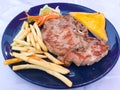 Grilled Pork chop Steak with gravy sauce, there are French fries and Salad with cream sauce on side dishes Royalty Free Stock Photo