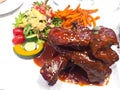 This is Grilled Pork chop Steak with gravy sauce, there are French fries and Salad on side dishes. All were served in a white Royalty Free Stock Photo