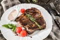 Grilled pork chop steak with rosemary, tomatoes and spices on wooden rustic background. Hot Meat Dishes. Royalty Free Stock Photo