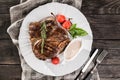 Grilled pork chop steak with rosemary, tomatoes and spices on wooden rustic background. Hot Meat Dishes Royalty Free Stock Photo