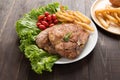 Grilled pork chop steak and vegetables with french fries on wood Royalty Free Stock Photo