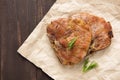 Grilled pork with herbs on a paper on wooden background Royalty Free Stock Photo