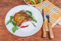 Grilled pork loin chop bone-in on dish, fork, knife Royalty Free Stock Photo