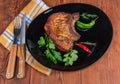 Grilled pork loin chop bone-in on dish, fork, knife Royalty Free Stock Photo