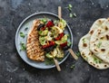 Grilled pork meat chops, vegetables mushrooms, peppers, zucchini skewers and naan flatbread on a dark background, top view Royalty Free Stock Photo