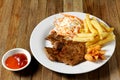 Grilled pork meat French fries and vegetables salad on plate Royalty Free Stock Photo