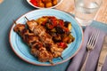 Grilled pork meat shashlik with sauteed vegetables