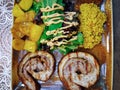 Grilled pork meat tavern food prepared and served with potatoes, green salad with sauce, and couscous top view close up