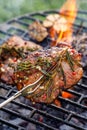 Grilled  pork neck, pork steak with the addition of herbs and spices ona flaming grill plate, close-up, top view. Royalty Free Stock Photo