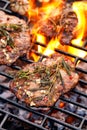 Grilled  pork neck, pork steak with the addition of herbs and spices ona flaming grill plate, close-up, top view. Royalty Free Stock Photo