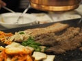 Grilled pork is on the pan in Thai style, Thai buffet with pork, chicken and other meats, cooked on brass barbecue pan, pork grill