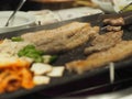 Grilled pork is on the pan in Thai style, Thai buffet with pork, chicken and other meats, cooked on brass barbecue pan, pork grill