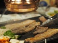 Grilled pork is on the pan in Thai style, Thai buffet with pork, chicken and other meats, cooked on brass barbecue pan, pork grill