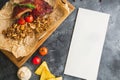 Grilled pork ribs with buckwheat, mushroom and tomatoes on old wooden cutting board. Flat lay, top view. Paper card with copy spac Royalty Free Stock Photo