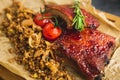 Grilled pork ribs, buckwheat with mushroom and tomatoes on vintage wooden cutting board. Close up view Royalty Free Stock Photo