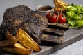 grilled pork ribs with french fries and vegetables on a wooden board Royalty Free Stock Photo