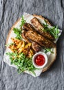 Grilled pork ribs and french fries on wooden board on grey background. Delicious lunch, appetizers, tapas Royalty Free Stock Photo