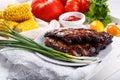 Grilled pork ribs. Meat bbq ribs served with sauce and fresh vegetables Royalty Free Stock Photo