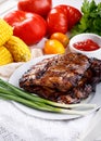 Grilled pork ribs. Meat bbq ribs served with sauce and fresh vegetables Royalty Free Stock Photo