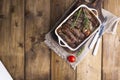 Grilled pork ribs. Meat with spices and herbs in dishes on wooden background. Lunch barbecue with salad and sauce. Free space for Royalty Free Stock Photo