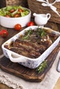 Grilled pork ribs. Meat with spices and herbs in dishes on wooden background. Lunch barbecue with salad and sauce. Free space for Royalty Free Stock Photo