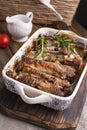 Grilled pork ribs. Meat with spices and herbs in dishes on wooden background. Lunch barbecue with salad and sauce. Free space for Royalty Free Stock Photo