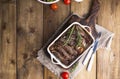 Grilled pork ribs. Meat with spices and herbs in dishes on wooden background. Lunch barbecue with salad and sauce. Free space for Royalty Free Stock Photo