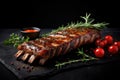 Grilled pork ribs with rosemary and tomatoes on a black background, grilled ribs with herbs and spices on Black background, copy