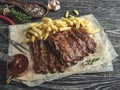 Grilled pork ribs with sauce on a cutting board, french fries Royalty Free Stock Photo