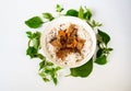 Grilled pork in soicy sauce with noodle, fresh herb leaf circle around plate