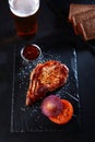 Grilled pork steak on a black background. Pork chops. Beer in a glass. Royalty Free Stock Photo