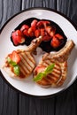 grilled pork steak with a bone with balsamic strawberries close-up on a plate. Vertical top view Royalty Free Stock Photo