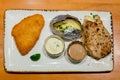 Grilled pork steak and fish steak, French fries and vegetables. Assorted meat from chicken and pork and various vegetables on b Royalty Free Stock Photo