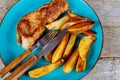 Grilled pork steak with french fries on blue plate Royalty Free Stock Photo