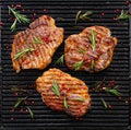 Grilled pork steak, pork neck with the addition of herbs and spices on the grill plate, top view Royalty Free Stock Photo