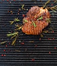 Grilled pork steak, pork neck with the addition of herbs and spices on the grill plate, top view Royalty Free Stock Photo