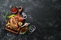 Grilled pork steak with spices on black stone background.