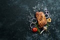 Grilled pork steak with spices on black stone background. Royalty Free Stock Photo