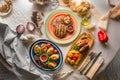 Grilled pork steak with vegetables. Fried sausages with garnish  baked potatoes with cheese and bacon. Concept - menu for a Royalty Free Stock Photo