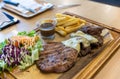 Grilled pork steak and vegetables . plate of grilled pork with french fries and salad on Table. Royalty Free Stock Photo