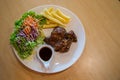 Grilled pork steak and vegetables . plate of grilled pork with french fries and salad on Table. juicy grilled pork chop neck cut Royalty Free Stock Photo